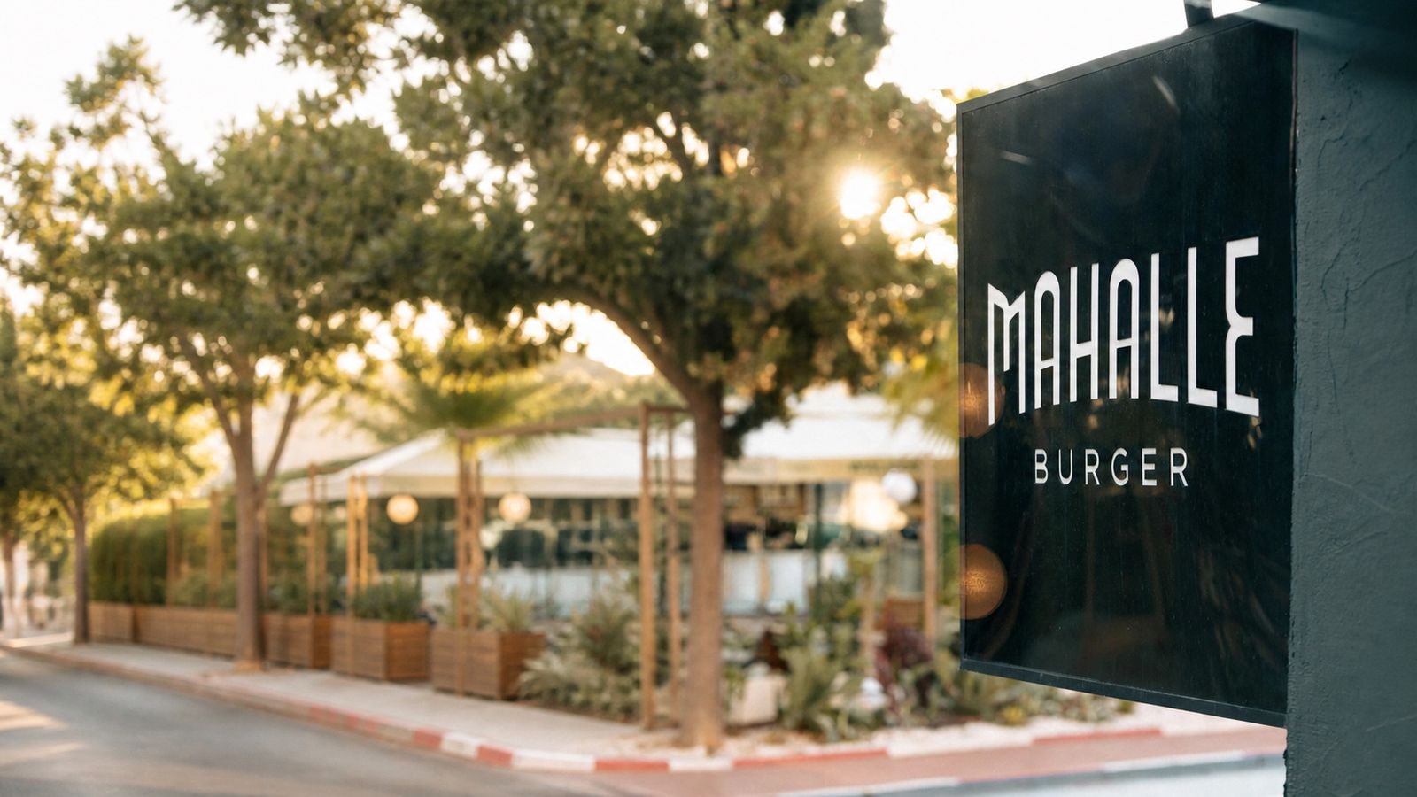Gün batımında Mahalle Burger Lara tabelası