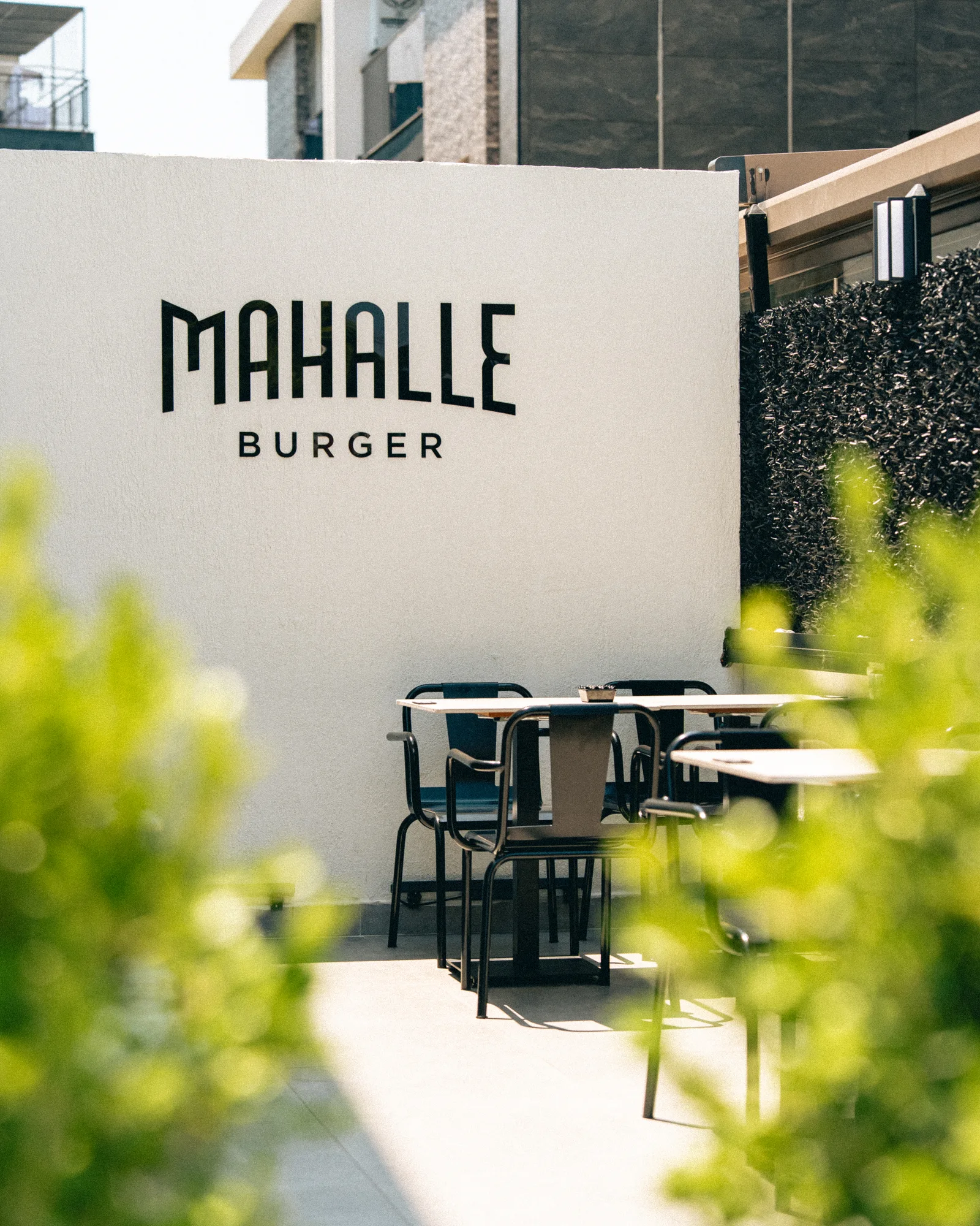 Güzeloba şubesinin Mahalle Burger tabelalı açık oturma alanı