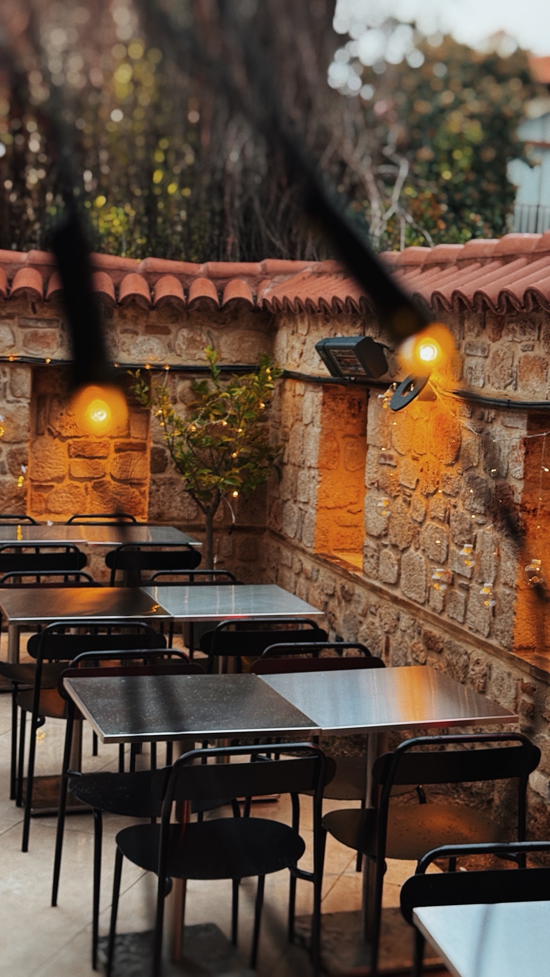 Mahalle Burger Kaleiçi’nin bahçe oturma alanı ve tarihi taş duvarları