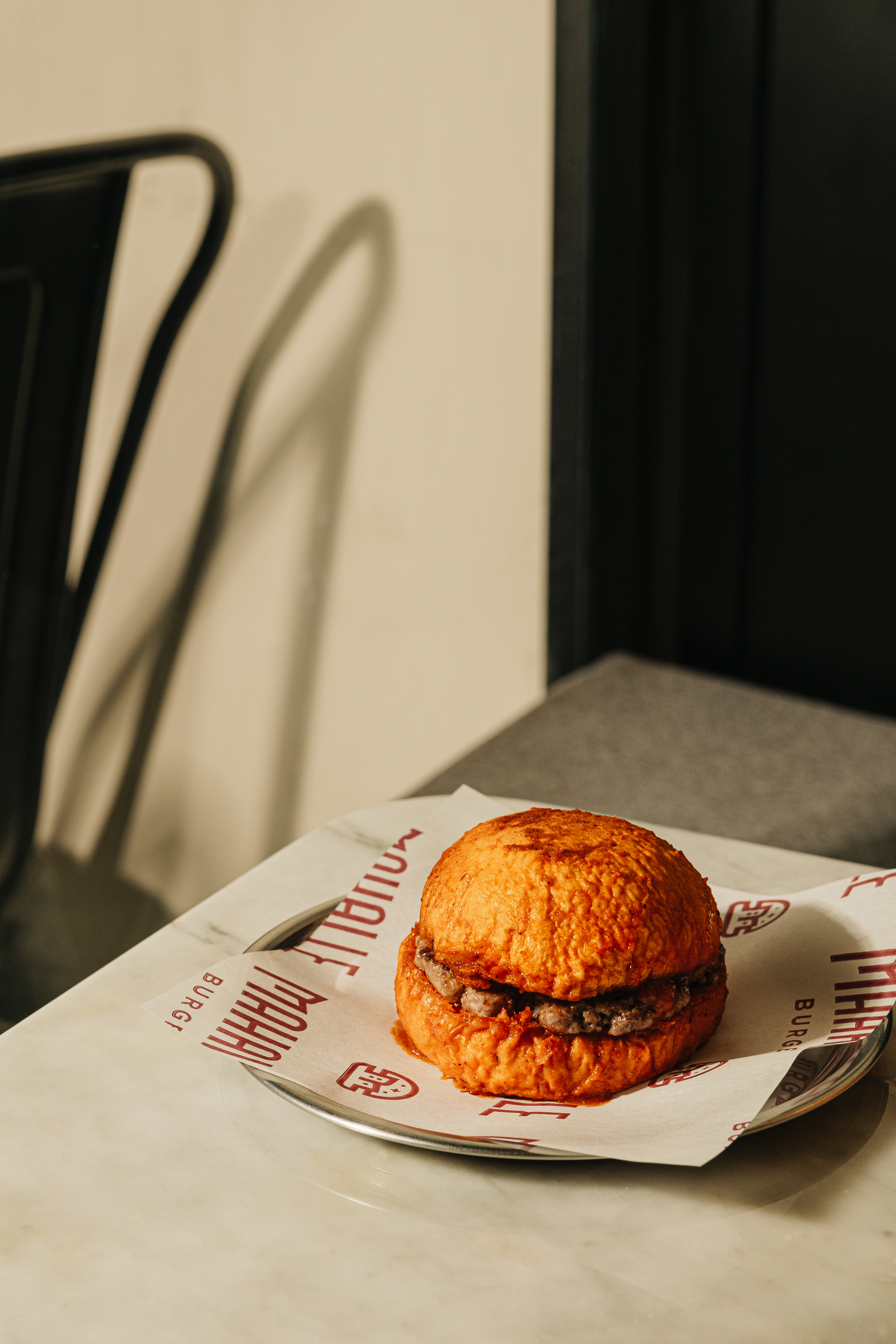 Mahalle Burger served on branded paper in the restaurant