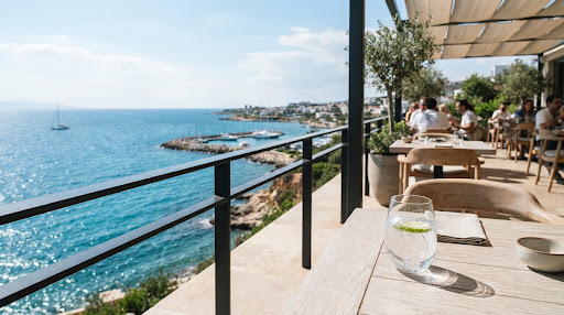 A sunlit restaurant terrace overlooking the Mediterranean