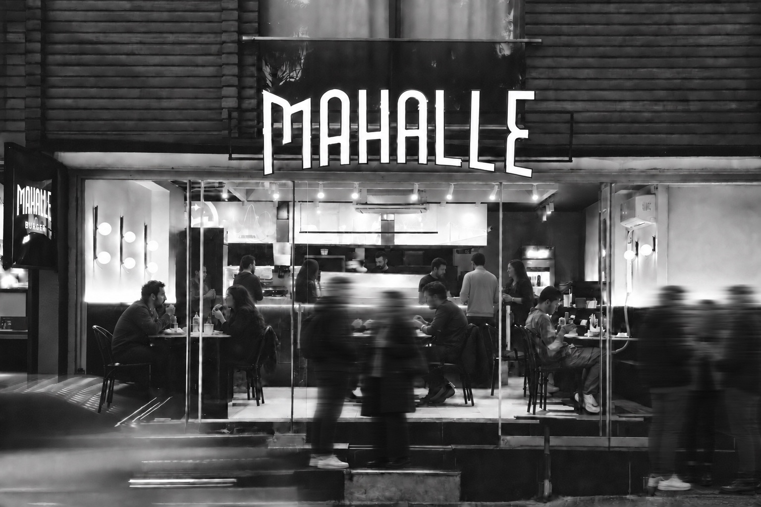 Lara Mahalle Burger’in merdivenli girişinde ve ön masalarında bir araya gelen insanlar
